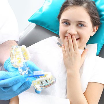 Bellevue Kids Dentist - Young girl covering her mouth